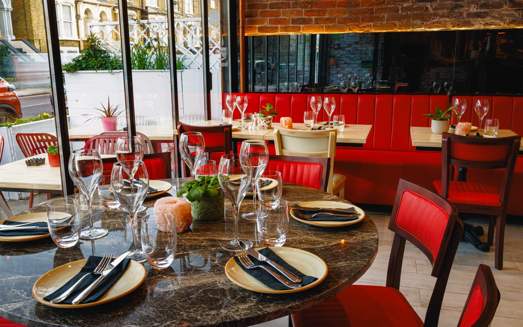 The dining room at Luna Llena, laid tables against red banquette seating